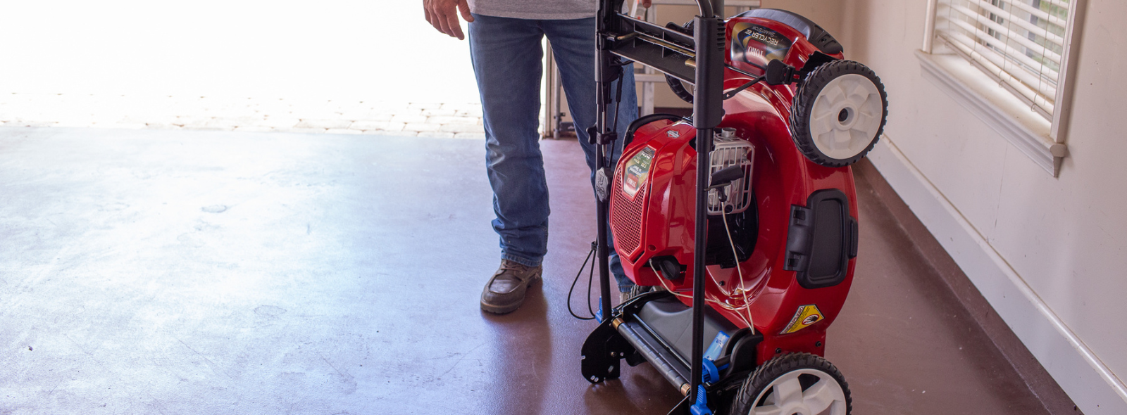 Person pushing a push mower cutting their lawn